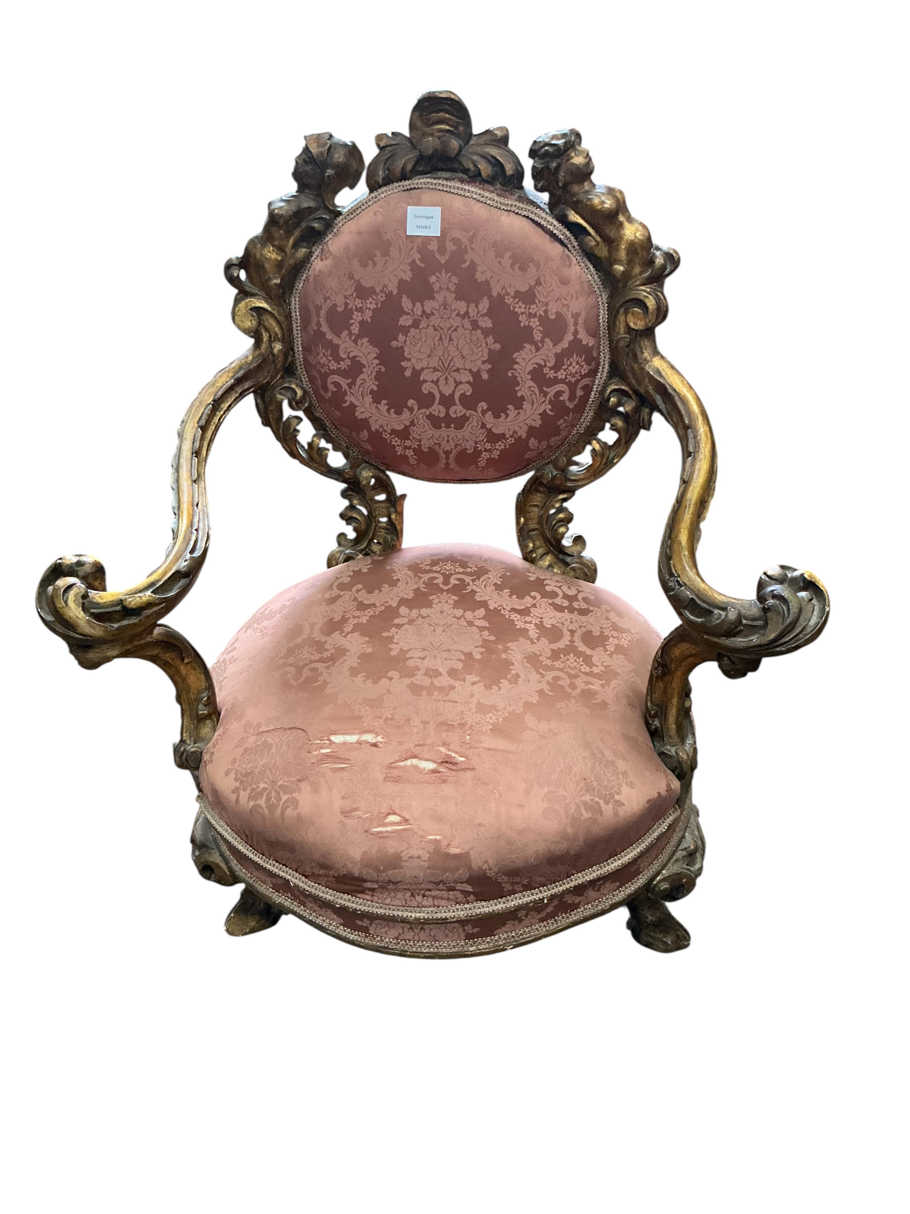 A 19th century Italian parcel gilt baroque revival armchair decorated with caryatids and leaf scrolls, upholstered in pink damask, fabric torn, width 80cm, depth 60cm, height 90cm